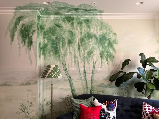 Close-up of hand-painted tonal green landscape mural with silver birch tree and distant rolling hills.