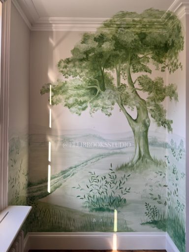 Bespoke hand-painted scenic mural with toile-style oak tree, green tonal hills and detailed foreground foliage.